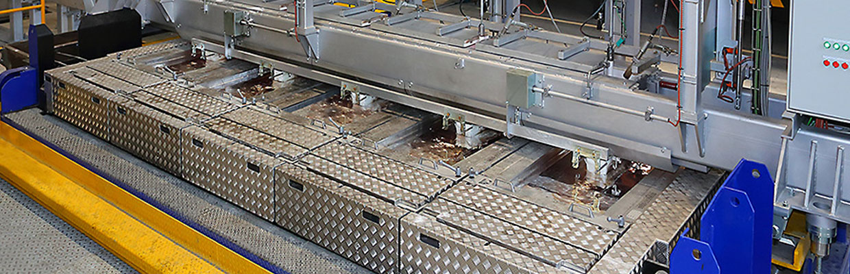 This photo shows a casting table with three variable molds which end sides can be positioned to successively cast slabs of different widths.